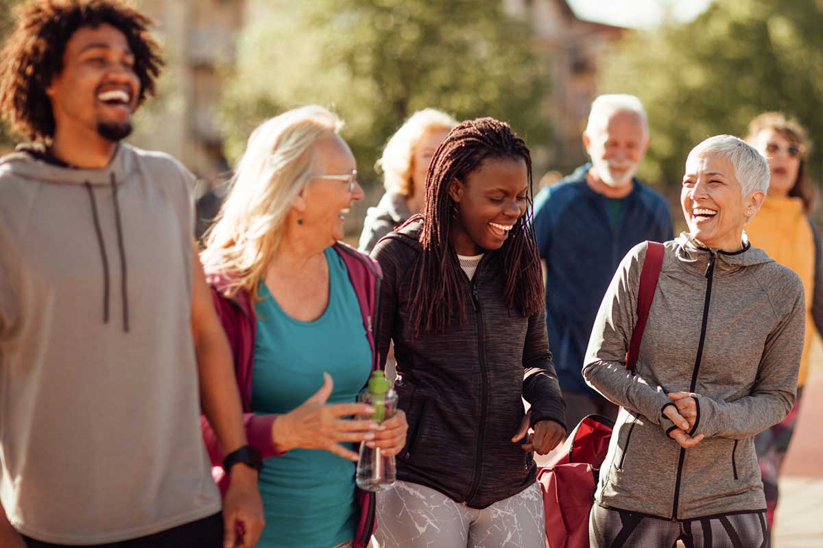 People walking outdoors together, smiling and enjoying a casual conversation.